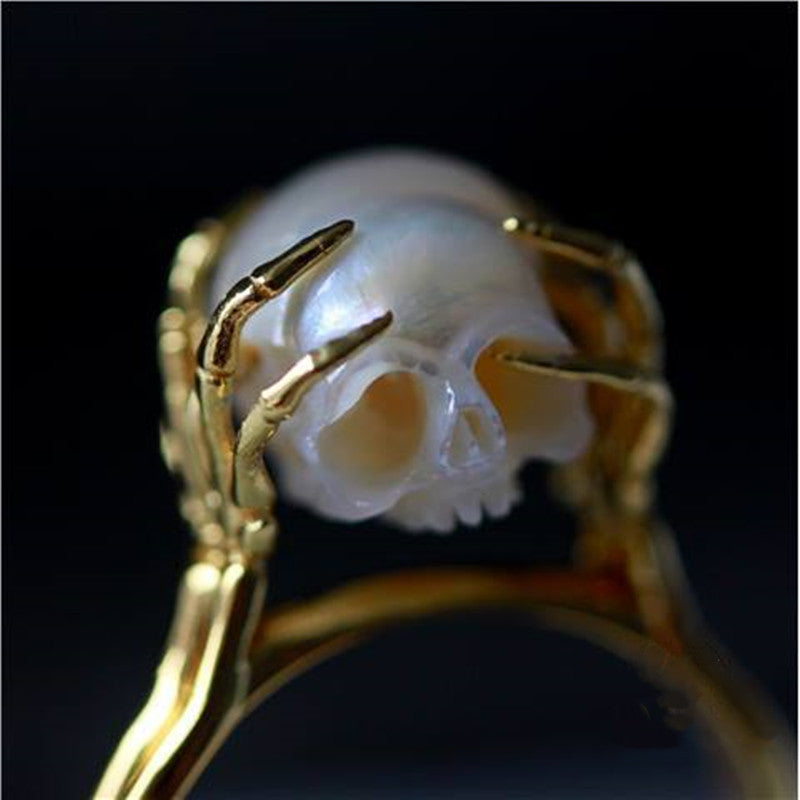Hand Carved Skull ring resting in sterling silver Hands