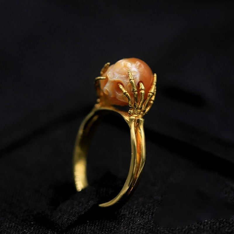 Hand Carved Skull ring resting in sterling silver Hands