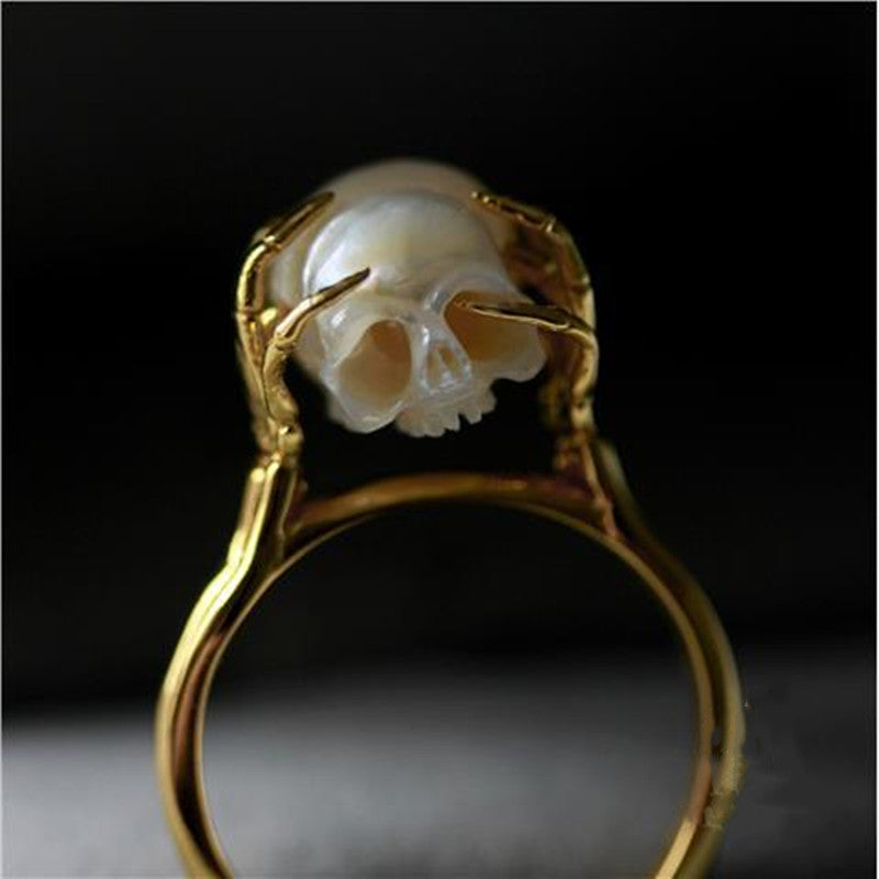Hand Carved Skull ring resting in sterling silver Hands